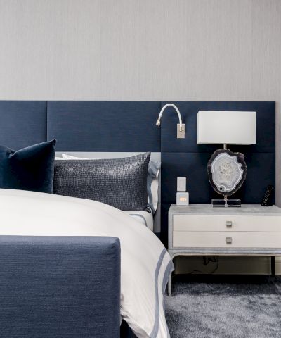 Elegant bedroom with a blue and white theme, modern furnishings, and decorative items